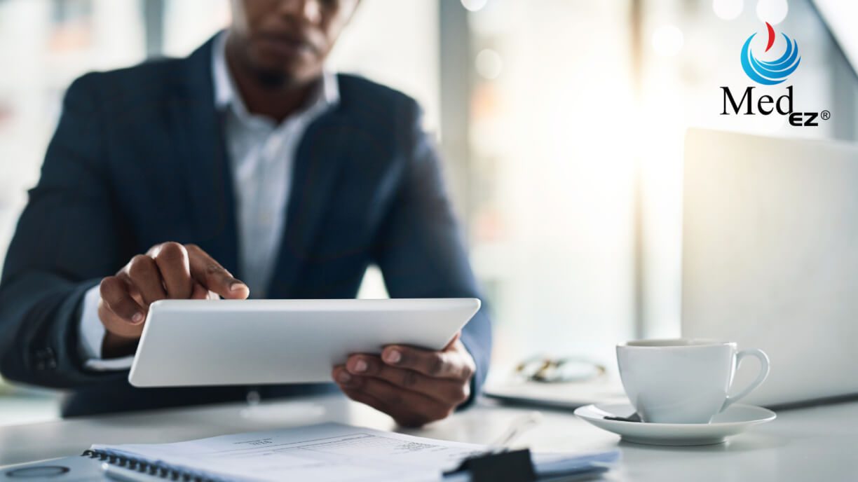 A man in a suit is using a tablet computer to access management software.