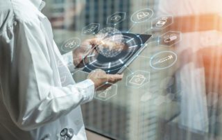 A man in a white coat is holding a tablet with medical icons on it, displaying the latest management software.