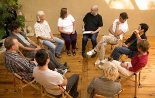 A group of people sitting in a circle, engaging in an addiction support session.