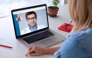 A woman is using management software on a laptop.